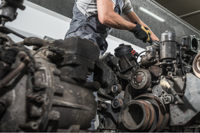 Mechanic fixing a semi truck engine in a repair shop